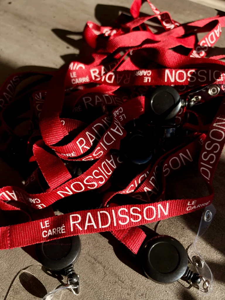 Lanières rouges imprimées au logo du Carré Radisson, avec enrouleurs