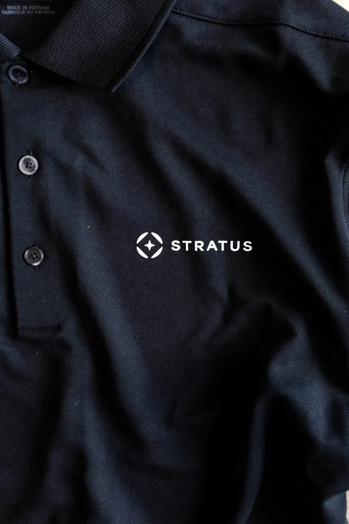 Polo noir personnalisé au logo de Stratus par Atelier QG
